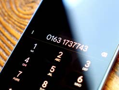 Auf dem Smartphone-Display ist eine Telefonnummer