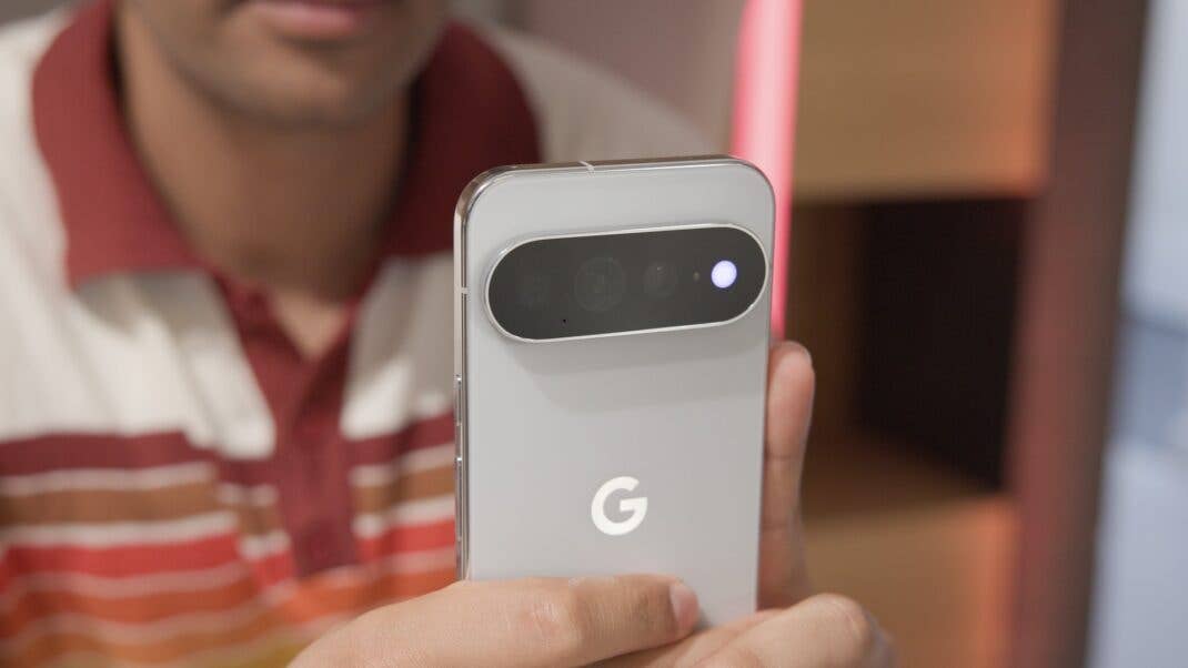 Person hält die Rückseite eines hellgrauen Google Pixel Smartphones in den Händen, wobei die Kamera-Leiste gut zu sehen ist.