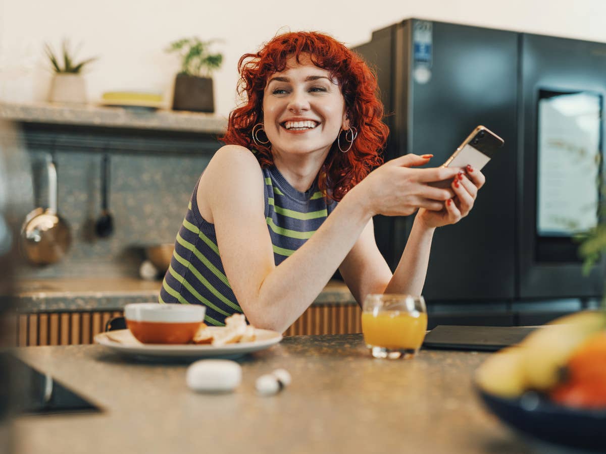 Eine Person hält ein Smartphone in der Hand und freut sich über die neuen Gesetze der EU, die auch ihr Smartphone in Zukunft besser machen