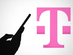 Eine Hand mit einem Smartphone als Silhouette - dahinter ist ein Telekom-Logo zu sehen.