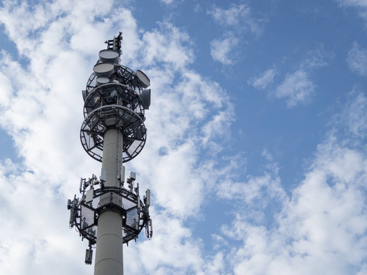 5G-Antennen-Mast vor bewölktem Himmel