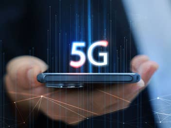 Smartphone in einer Hand mit übergelagertem 5G-Symbol.