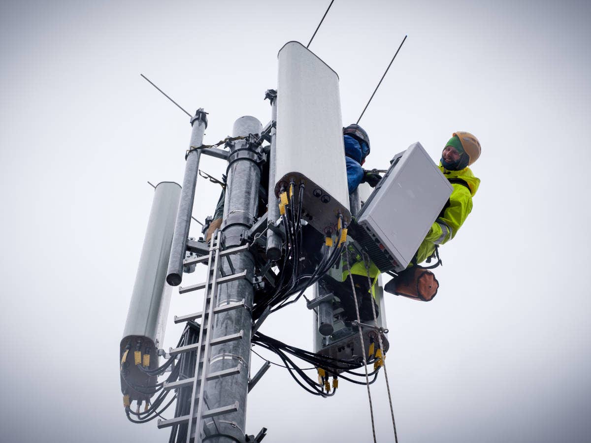 Techniker montieren eine 5G-Antenne an einer Basisstation