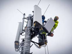 Techniker montieren eine 5G-Antenne an einer Basisstation