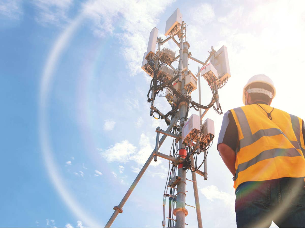 Ingenieur arbeitet vor Ort mit einem Telekommunikationsturm.