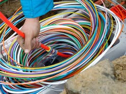 Bunte Leerrohre für Glasfaserleitungen in einer Baugrube