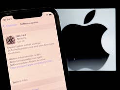 iOS 14.8 Update auf einem iPhone vor Apple-Logo im Hintergrund.