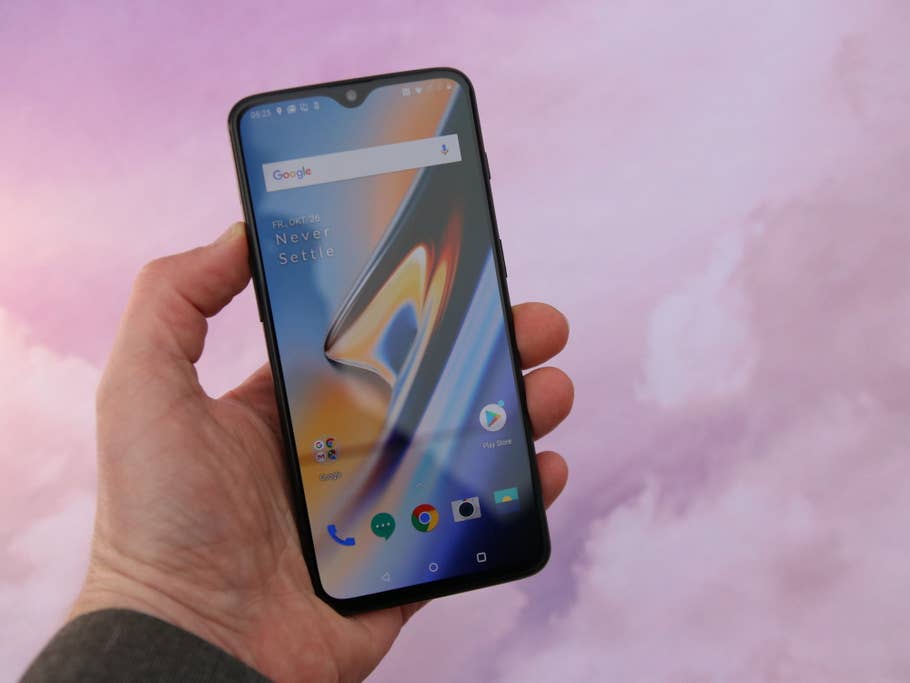 OnePlus 6T in der Handy mit aktiviertem Display vor rosa Hintergrund