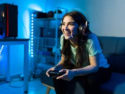Ab September: Eines der beliebtesten Spiele wird noch viel besser Junge Frau sitzt vor einem Ferneher und spielt ein Computerspiel.
