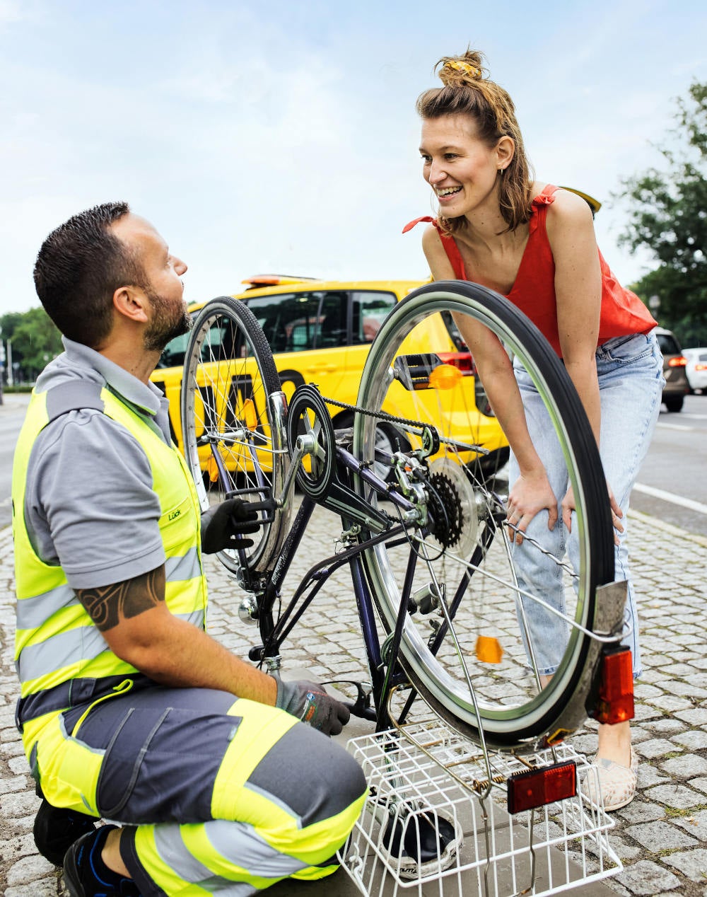 ADAC Pannenhelfer hilft einer Frau bei einer Radpanne.