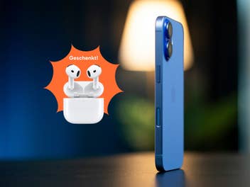 Ein iPhone steht auf einem Tisch, davor sind AirPods abgebildet.