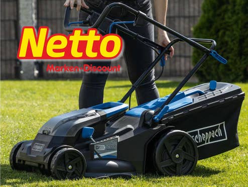 Eine Person steht mit einem Akku-Rasenmäher in einem Garten