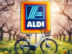 Fahrrad vor einem Aldi-Logo im frühlingshafter Umgebung.