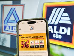 Info zu neuen Aldi-Talk-Tarifen auf einem Smartphone-Display vor Logos von Aldi Nord und Aldi Süd.