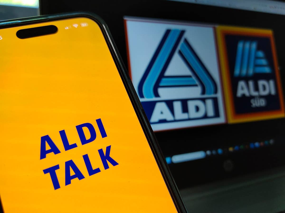 Aldi Talk-Logo auf einem Smartphone mit Logos von Aldi Nord und Aldi Süd im Hintergrund.
