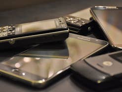 Einige alte Handys und Smartphones liegen auf einem Tisch