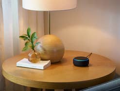Der Echo Dot steht auf einem kleinen Tisch
