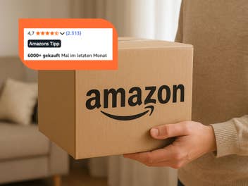 Person hält ein Amazon-Paket.