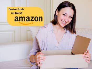 Frau sitzt auf einem Sofa mit einem Paket in der Hand