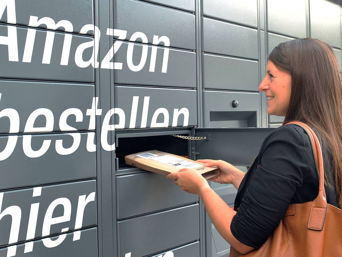 Eine Frau nimmt ein Paket aus einem Amazon Locker