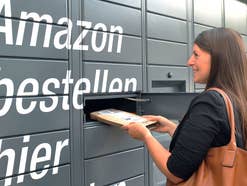 Eine Frau nimmt ein Paket aus einem Amazon Locker