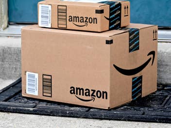 Pakete von Amazon stehen vor einer Haustür.