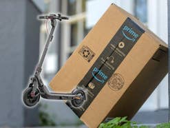 Amazon-Paket an eine Wand angelehnt daneben ein E-Scooter von Segway