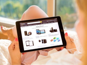 Frau surft im Amazon Online Shop auf einem Tablet