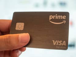 Eine Hand hält die Amazon Visa Kreditkarte