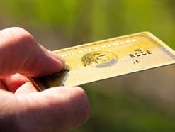 Goldene American Express Kreditkarte in einer Hand