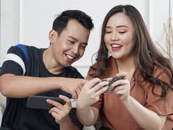 Zwei Personen schauen sich Fotos auf ihren Android-Smartphones an