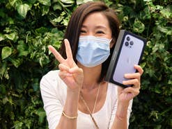 Frau freut sich über ein neu gekauftes iPhone von Apple.