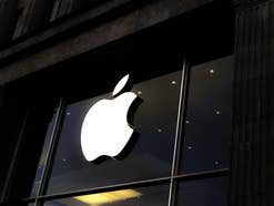 Das Apple Logo leuchtend über einem Store-Eingang