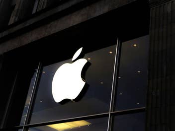 Das Apple Logo leuchtend über einem Store-Eingang