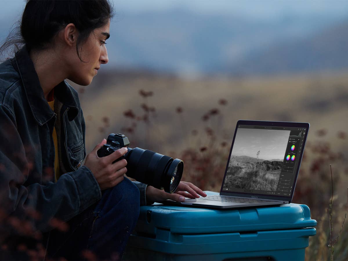 Fotografin mit Kamera und MacBook Pro