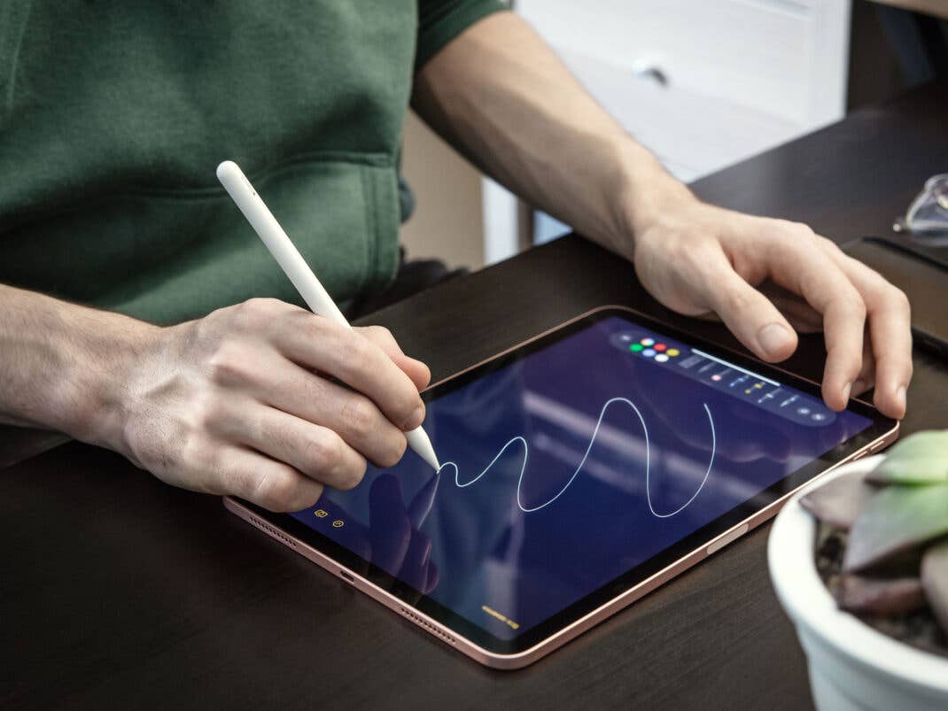 Eine Person zeichnet mit einem Apple Pencil Pro Skizzen auf ein iPad