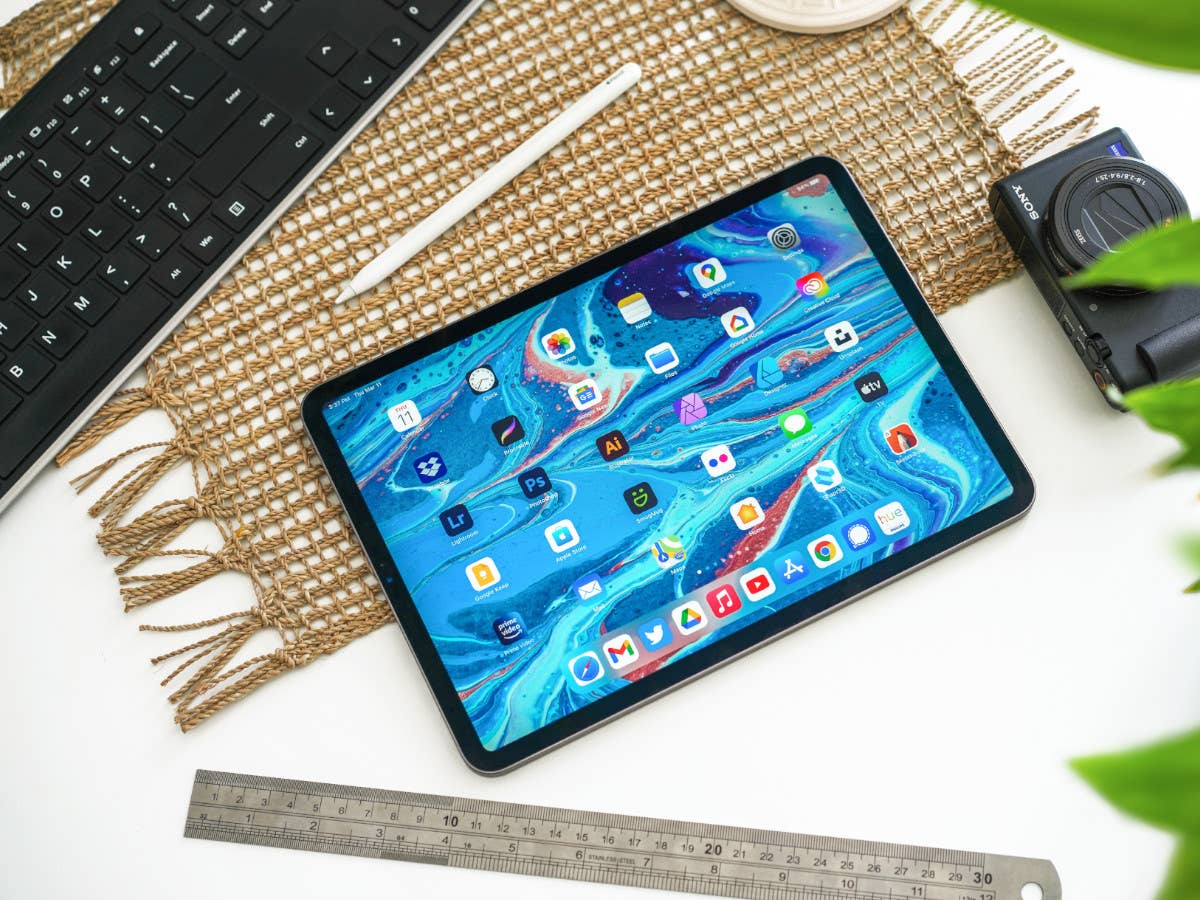 Gekaufte Apps auf einem iPad, das auf einem Schreibtisch neben anderen Utensilien liegt.