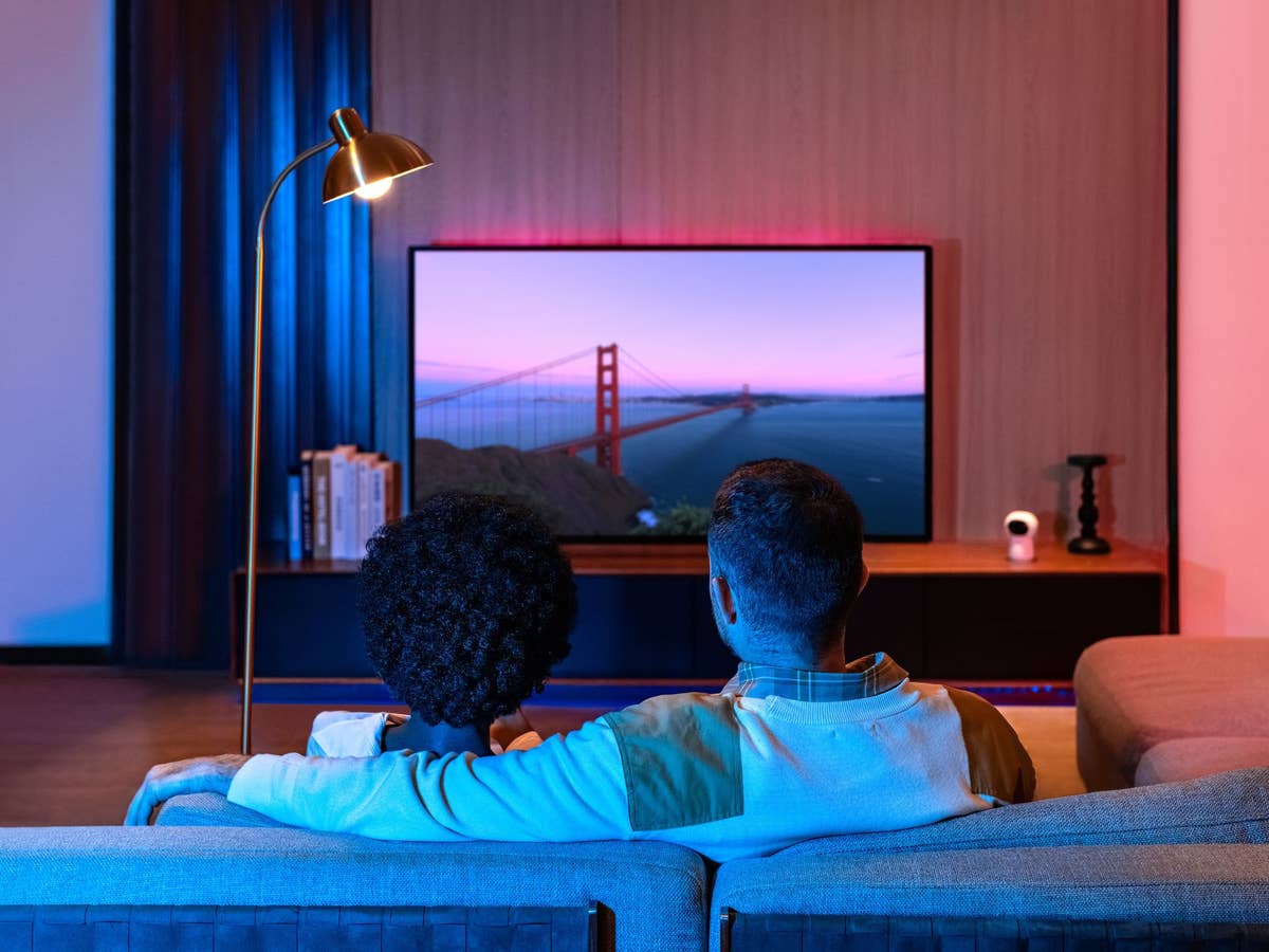 Pärchen sitzt auf einem Sofa und schaut Fernsehen