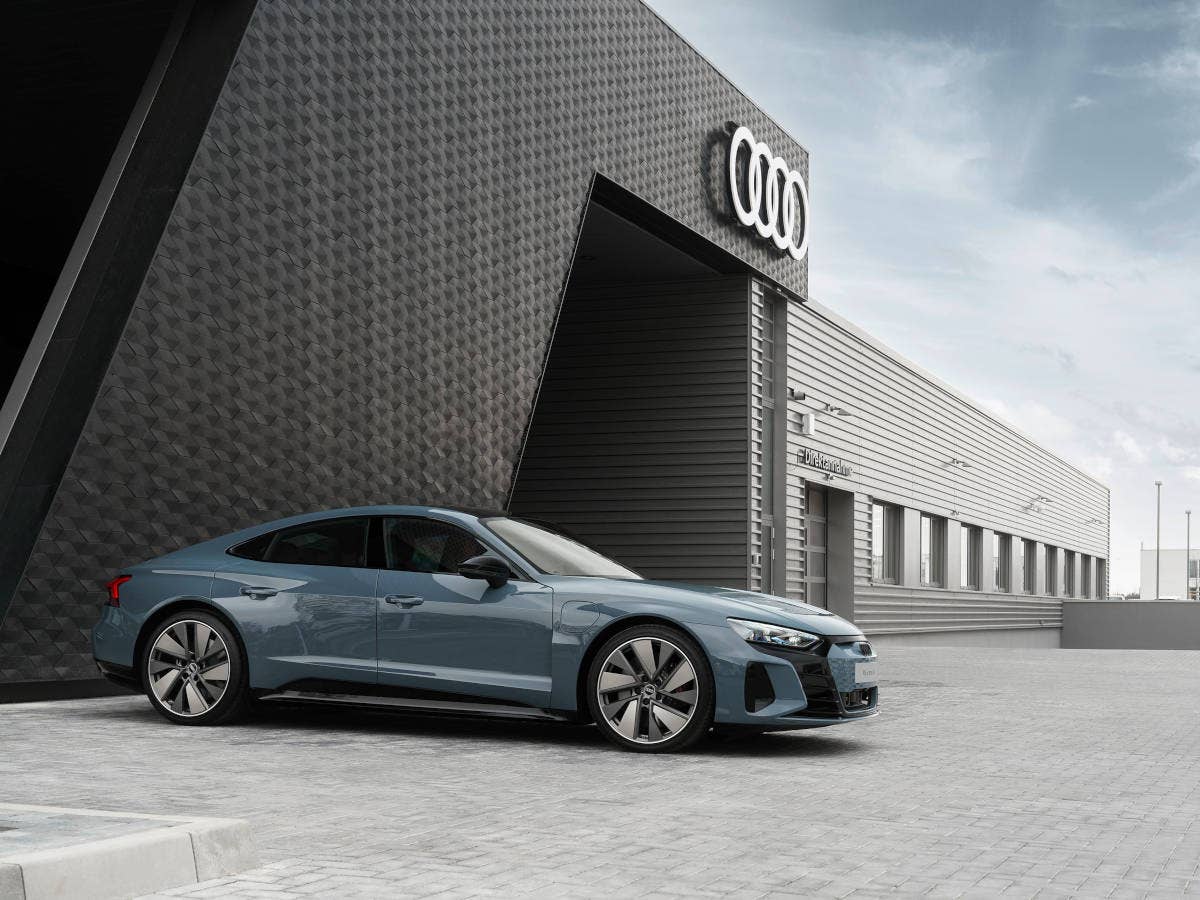 Audi e-tron GT vor einer Werkstatt geparkt.