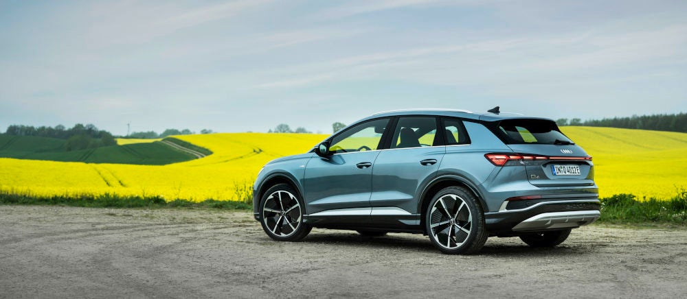 Audi Q4 e-tron steht vor einem gelb leuchtenden Raps-Feld.