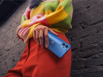 Frau hält ein blaues Motorola Moto G14 in der Hand.