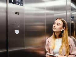 Eine Frau steht in einem Aufzug