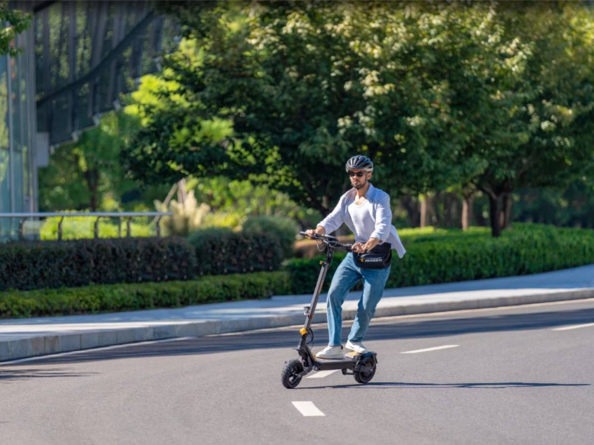Mann steht auf dem E-Scooter von Ausom