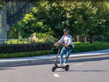 Mann steht auf dem E-Scooter von Ausom