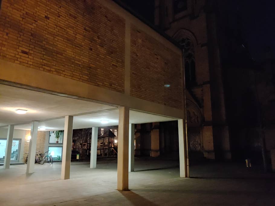 Hauseingang mit Kirche im Hintergrund bei Nacht