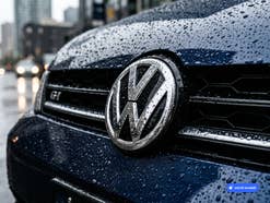 VW-Logo an der Front eines Autos. KI-generiert