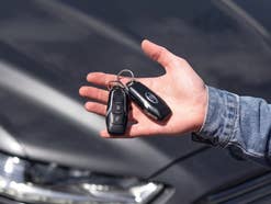Ein Autoschlüssel liegt in einer Hand.