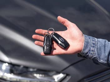Ein Autoschlüssel liegt in einer Hand.