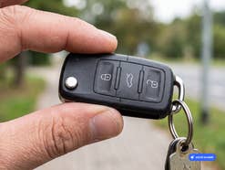 Zwei Finger halten einen Autoschlüssel