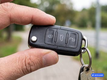 Zwei Finger halten einen Autoschlüssel